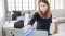 Woman in the office using disinfectant for sanitizing monitor during COVID-19 pandemic