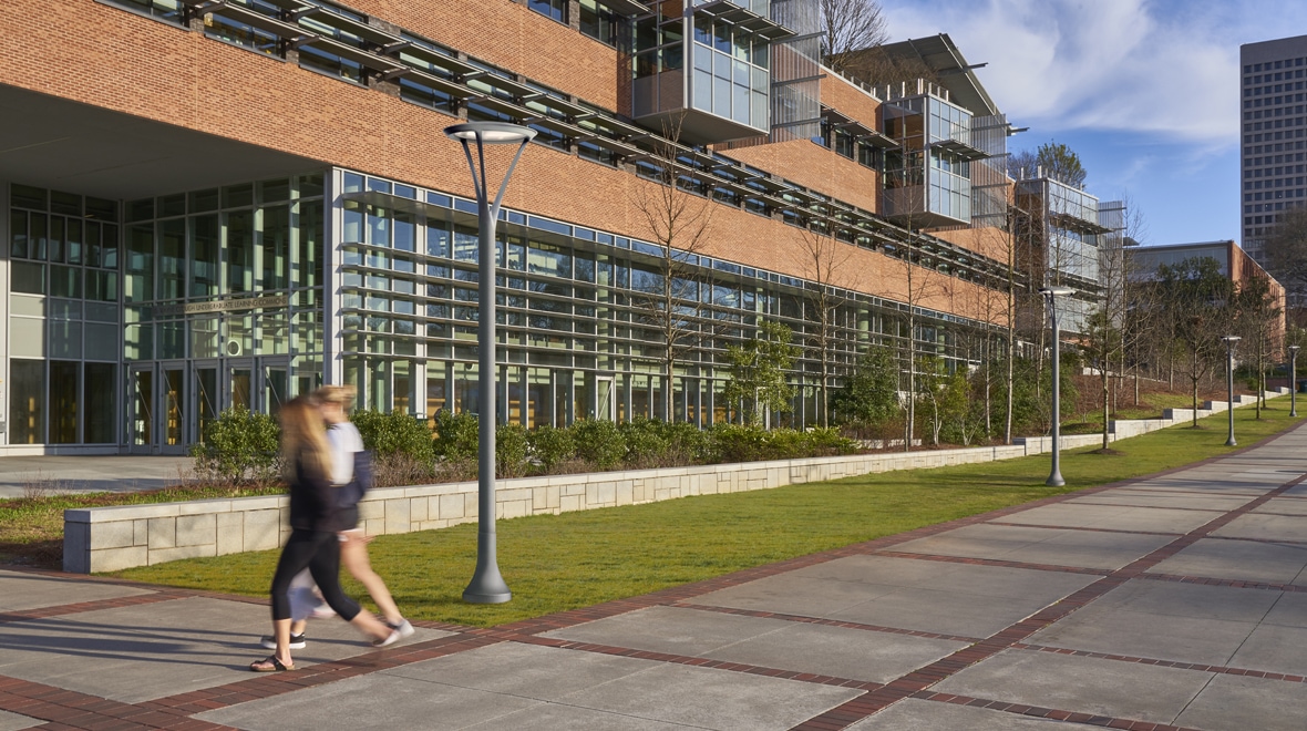 Daytime- The LuxeScape architectural post top light lines the sidewalk on a college campus.